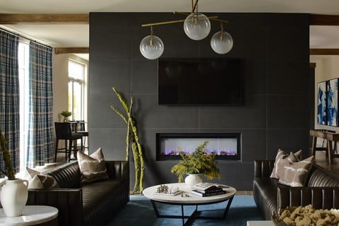 A modern living room with a fireplace and a flat screen TV mounted above it.